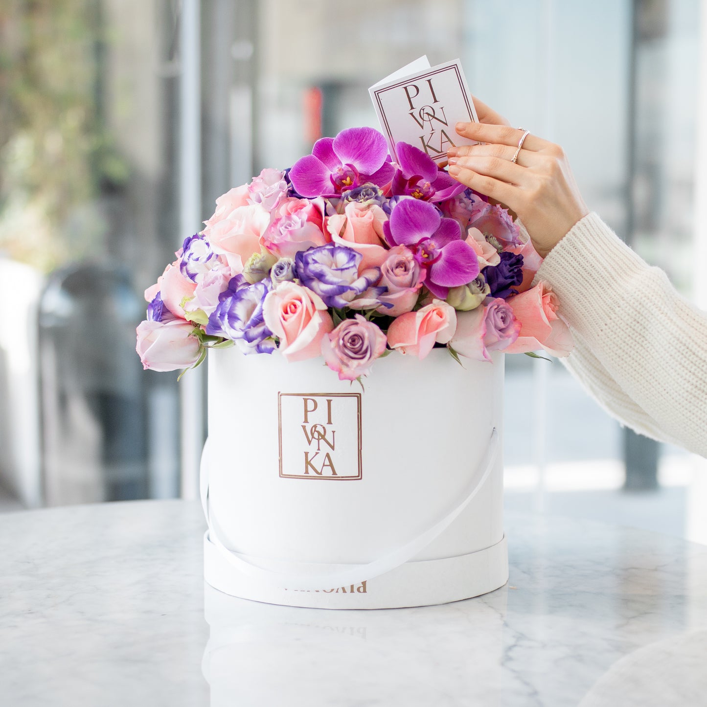 Pivonka Flores Monterrey. Rosas, lisianthus y orquídeas en caja cilíndrica.